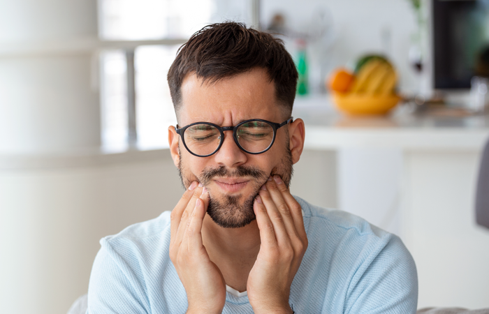 man holding his face in pain