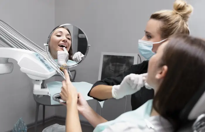 dentist discussing patients teeth with a mirror